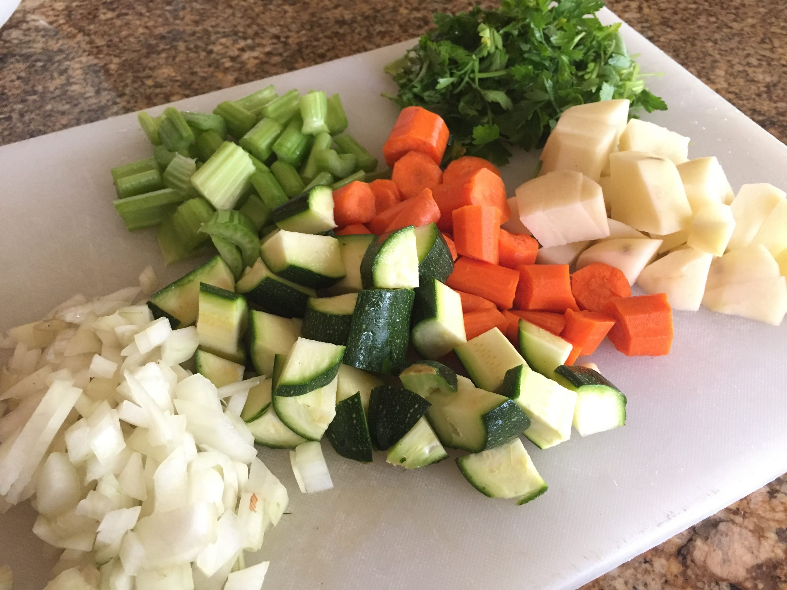 Diced onion, zucchini, carrots, potato, celery and herbs for chicken soup with vegetables