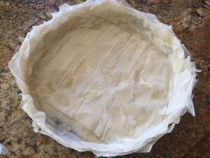 Arrange phyllo pastry to make a shell on tart pan