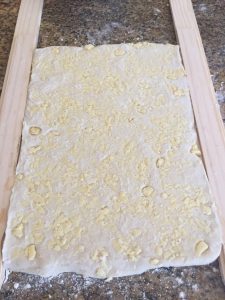 Roll dough until it reaches the height of the paint stick.