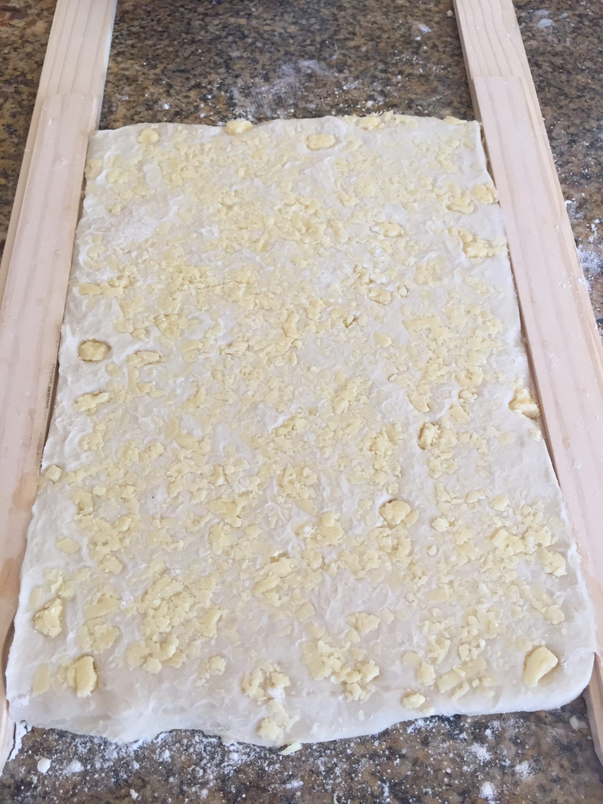 Roll dough until it reaches the height of the paint stick.