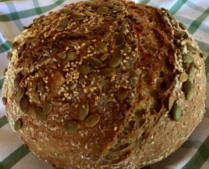 Baked whole wheat seeded sourdough with toppings added after bulk fermentation