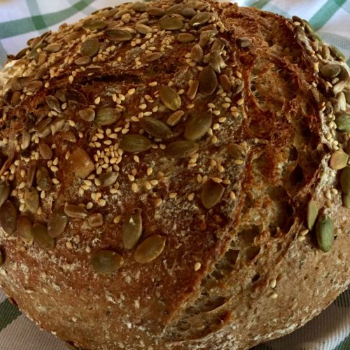Baked whole wheat seeded sourdough with toppings added after bulk fermentation