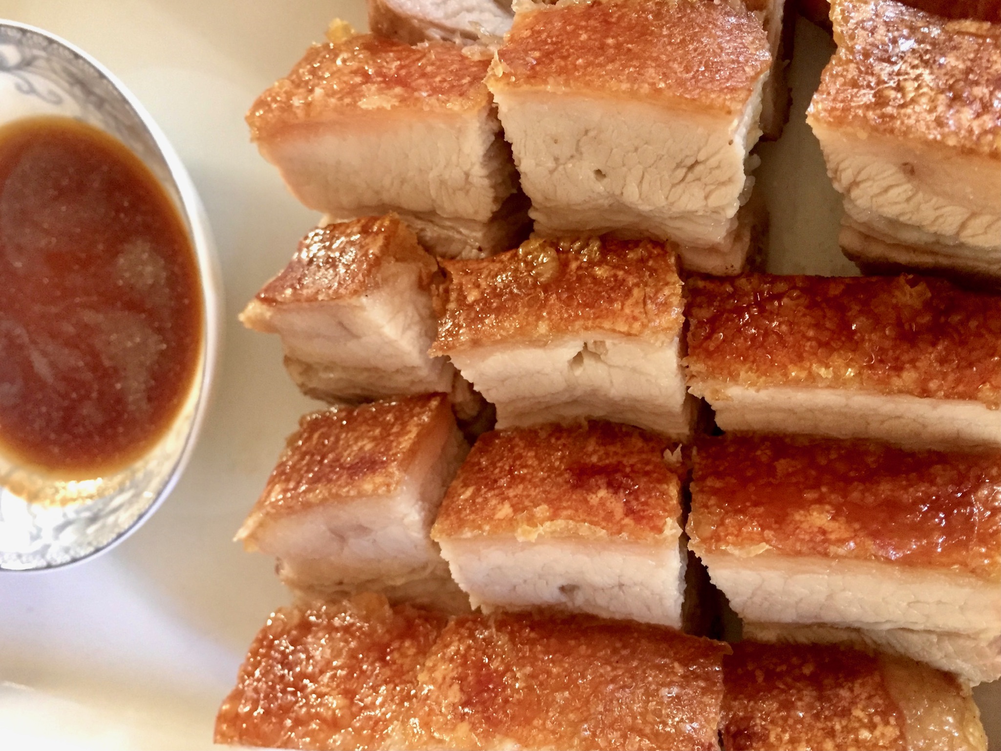Crispy pork belly served with soy sauce and white pepper.