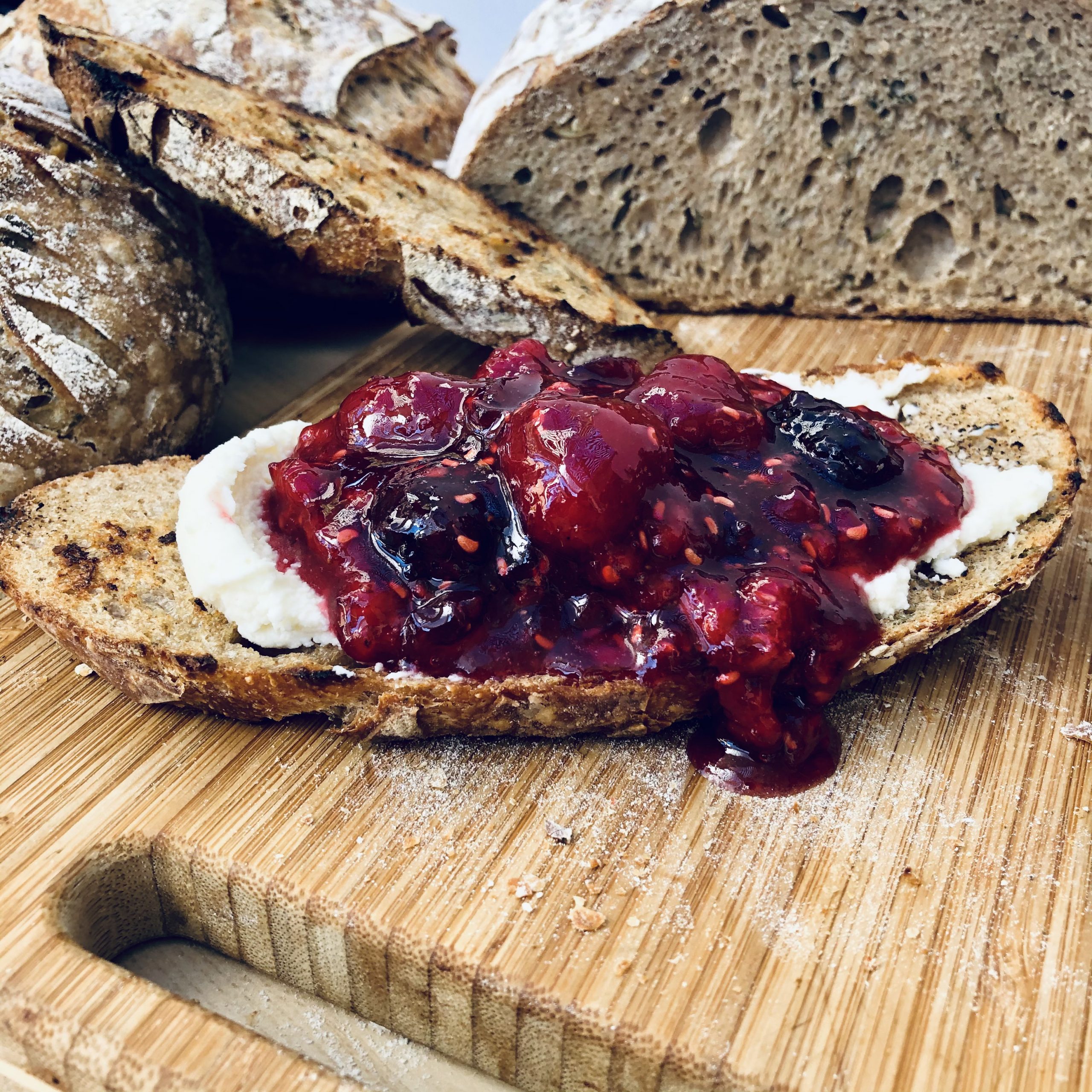 Mascapone cheese with berry preserves on roasted garlic and herbs sourdough
