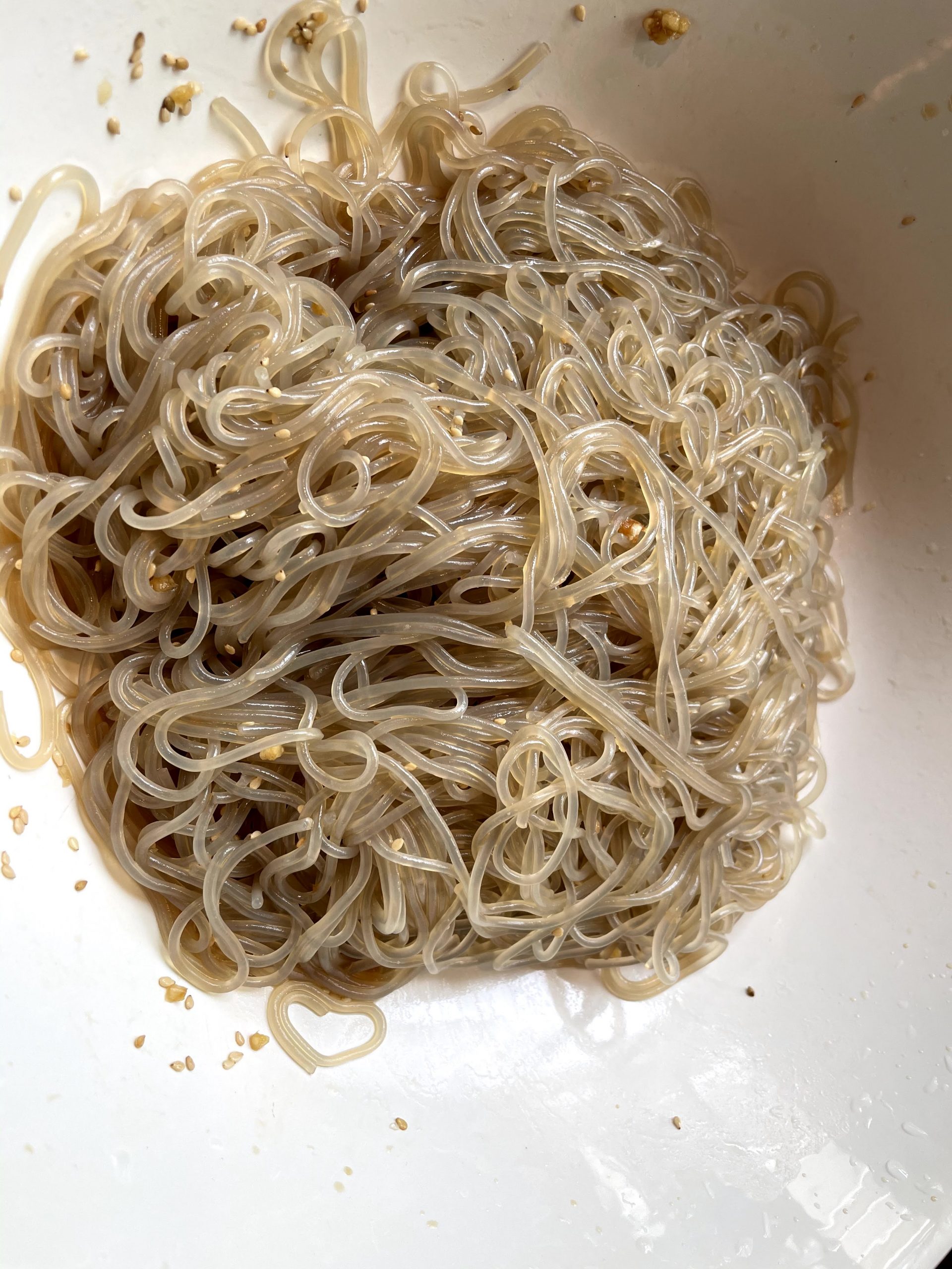 Japchae noodles marinating in sauce.
