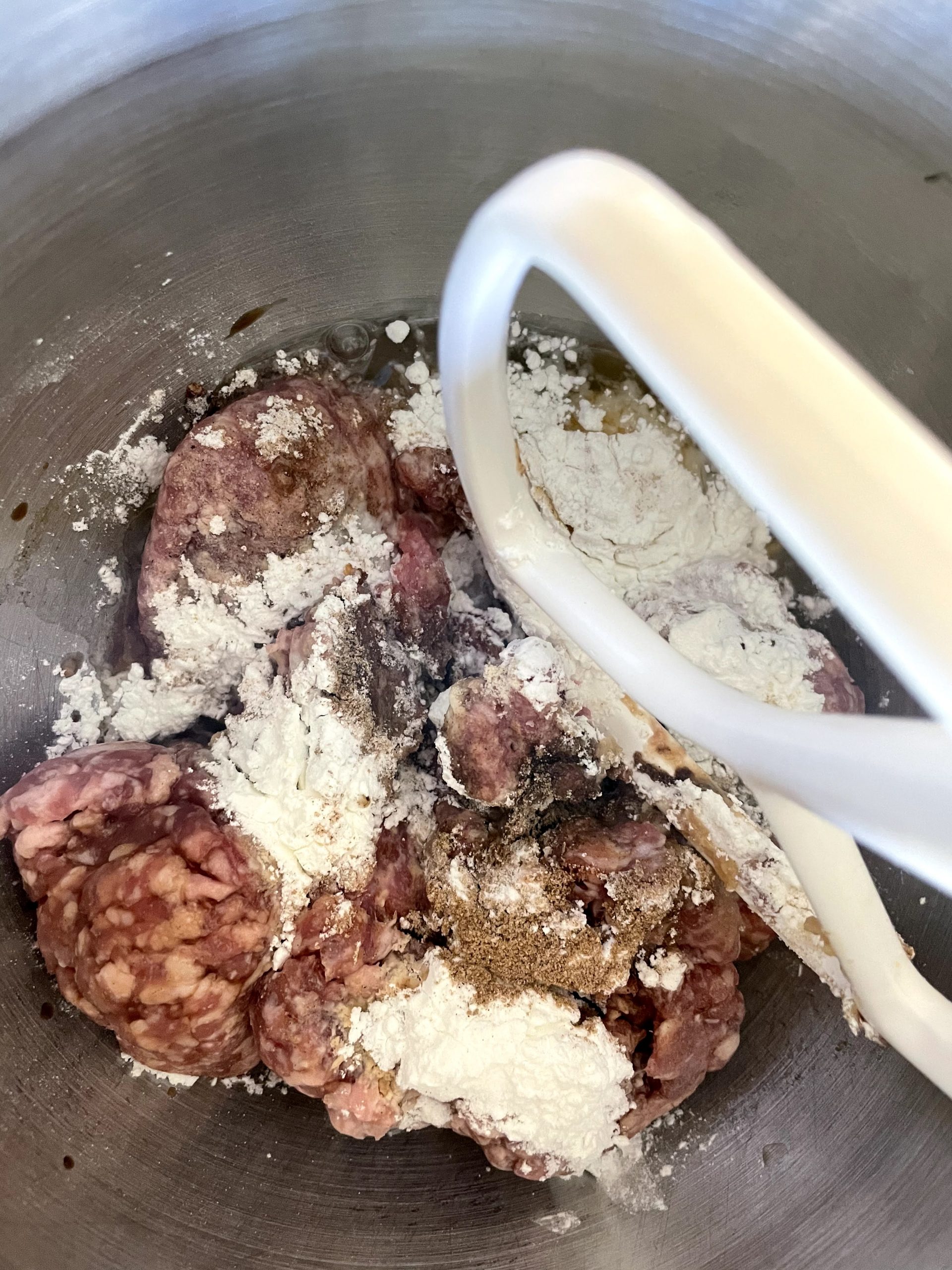 Add ingredients and ground pork to mixer.