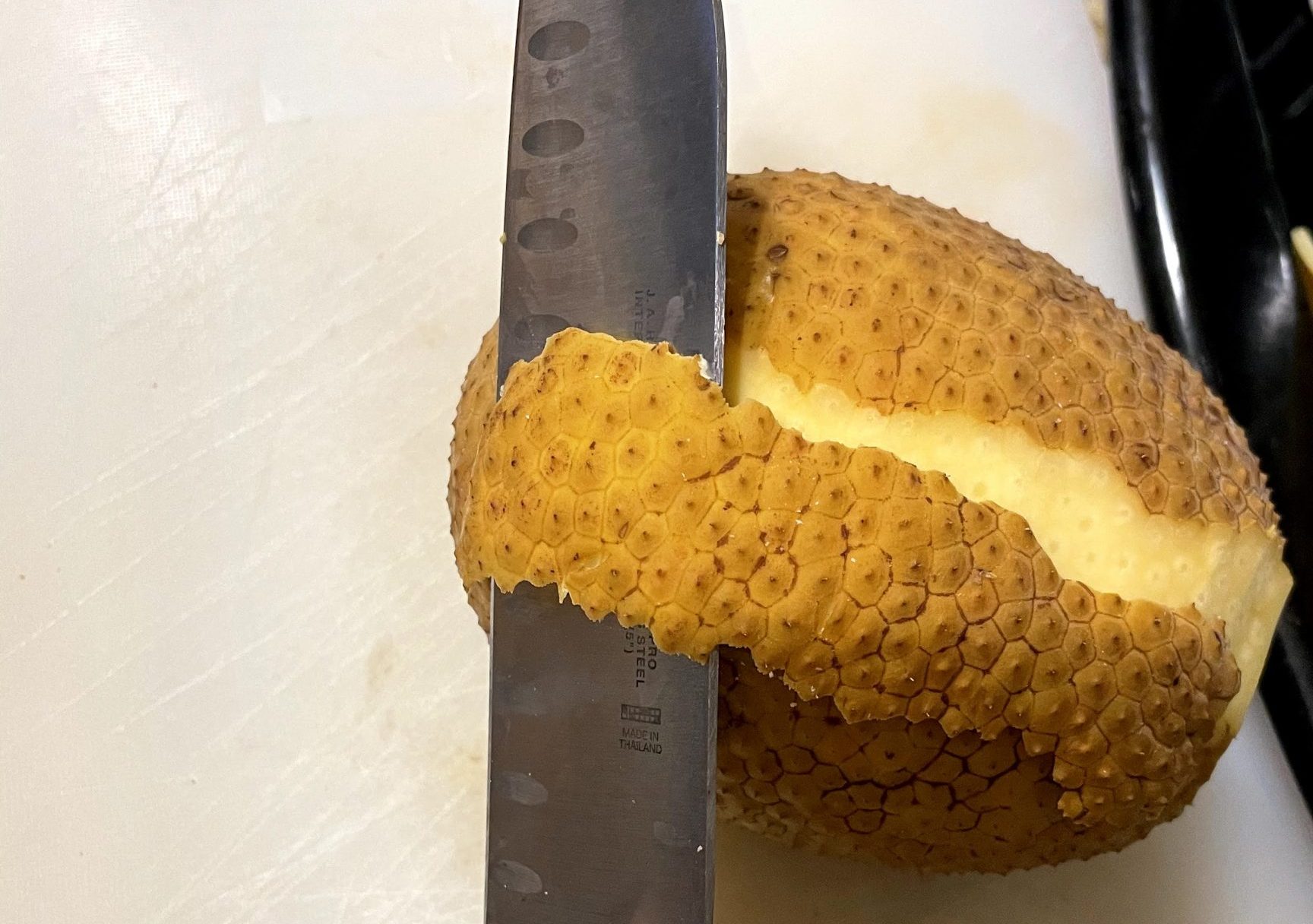Peel breadfruit with paring knife.
