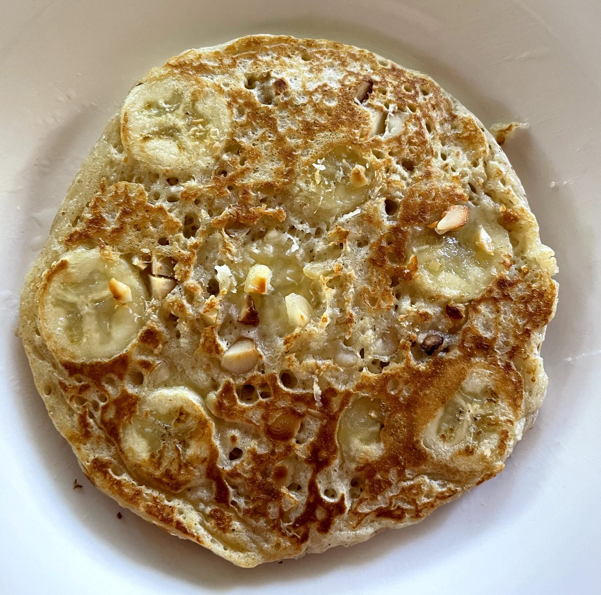 Cooked pancake with caramelized banana, macadamia nuts and coconut.