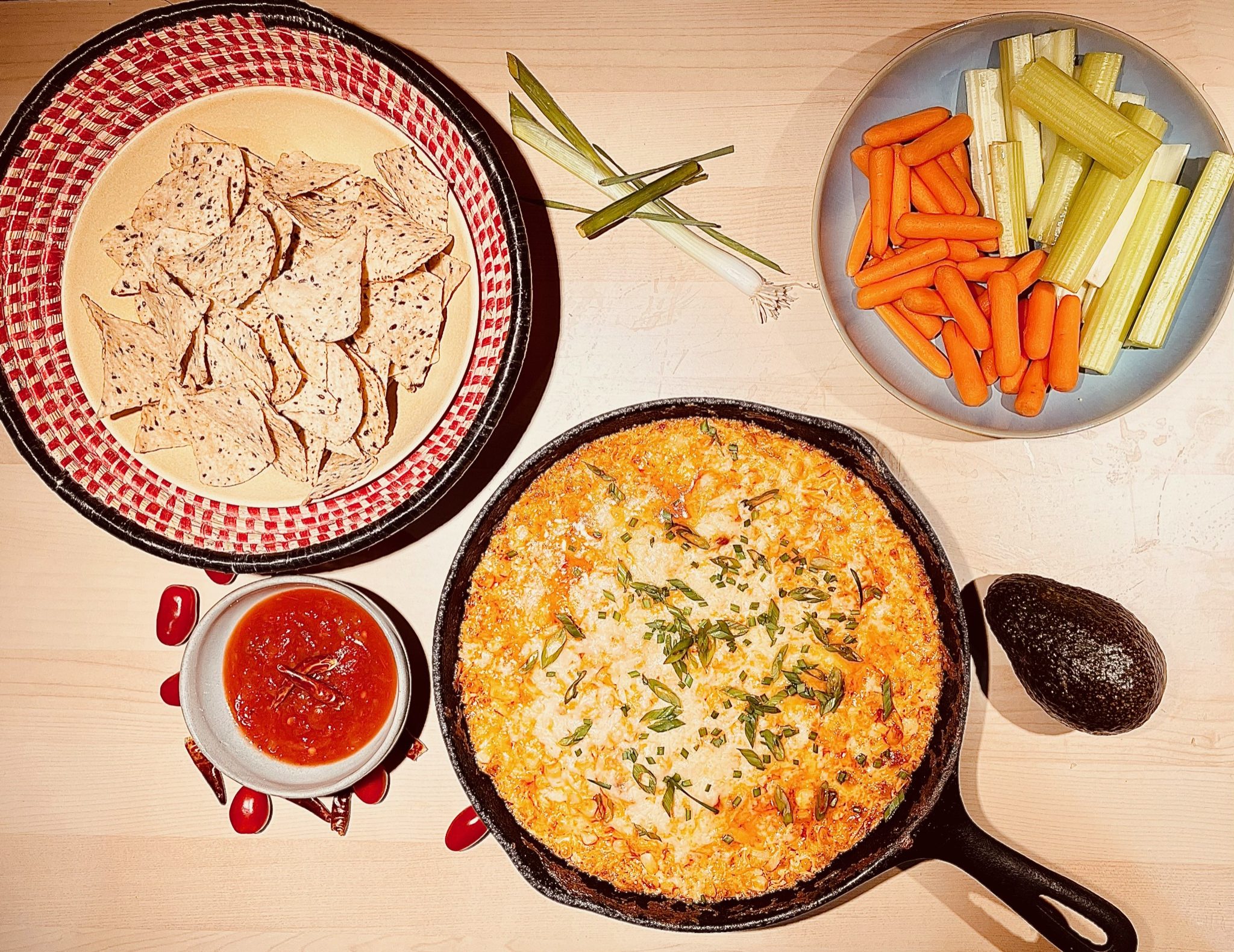 Bubbling buffalo chicken dip with chips and veggies.
