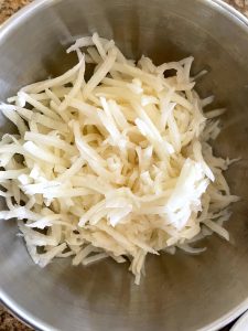 Shredded potatoes are combined with meat.