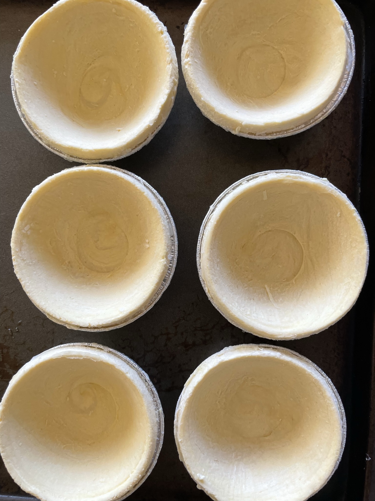 Place frozen egg tart shells onto a baking tray.