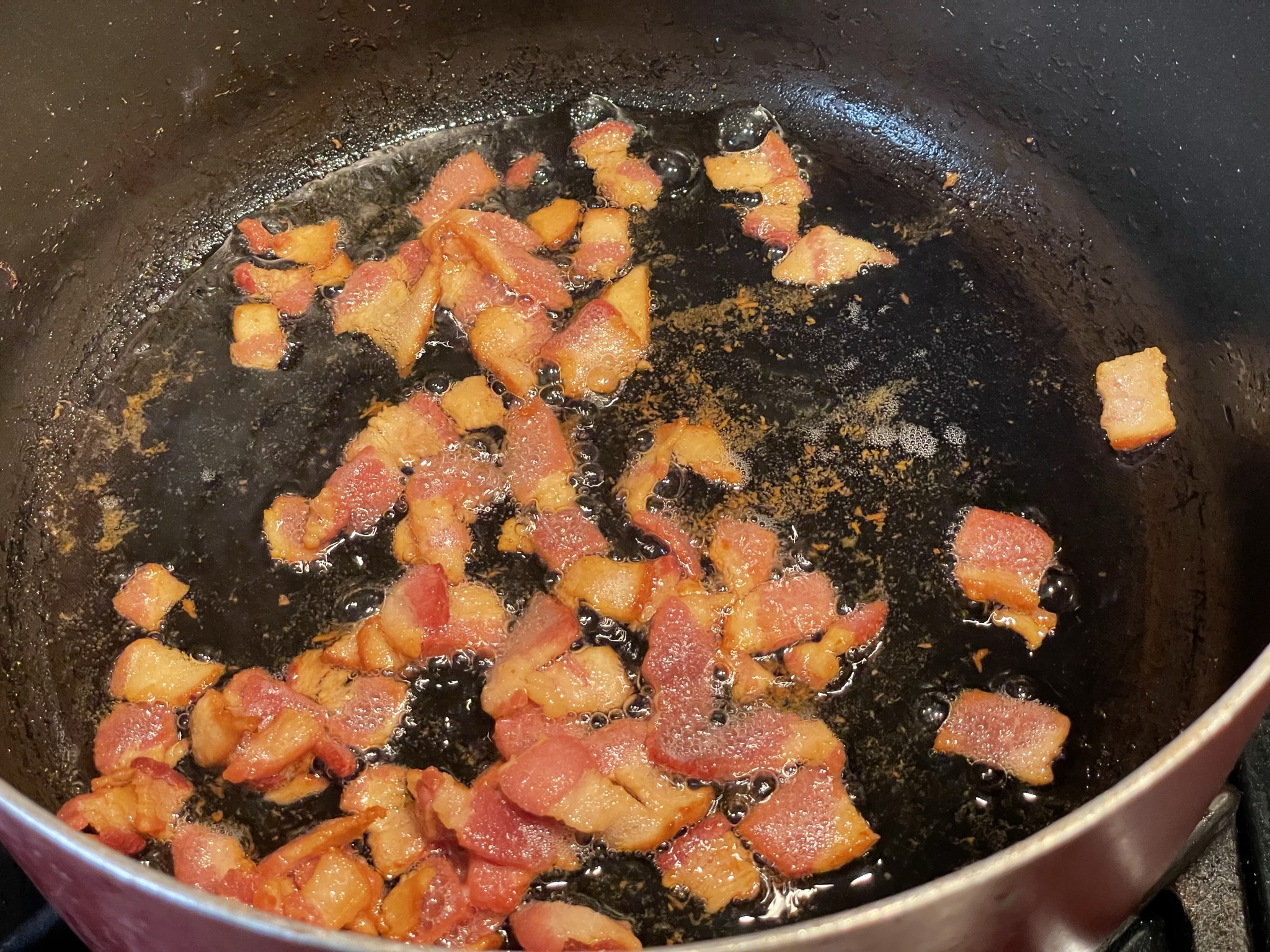 Cook bacon until fat is rendered.
