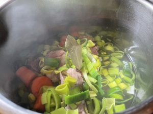 Place vegetables into ham stock with bay leaf.